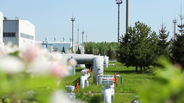 apple blossom then slow focus on compressor station with turbine