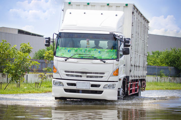 Obraz na płótnie Canvas Splash by a truck as it goes through flood water