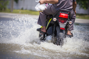 Splash by a motorcycle as it goes through flood water