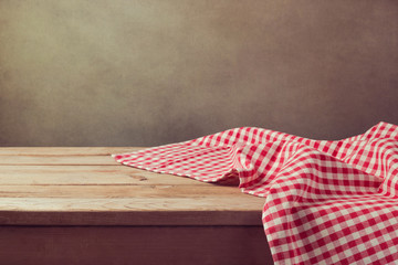 Empty wooden deck table with checked tablecloth