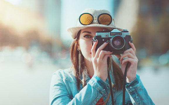 Hipster girl making picture with retro camera, focus on camera