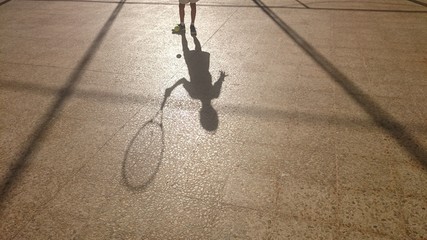 Sombra de niño con raqueta y pelota