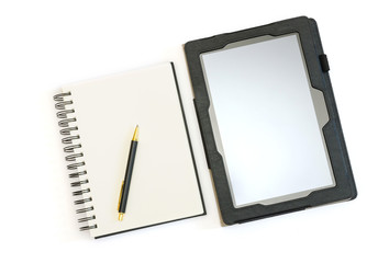 a tablet pc next to a traditional blank notebook with a pen