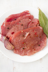 raw pork with garlic on white plate