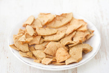 dried apples on plate on white background