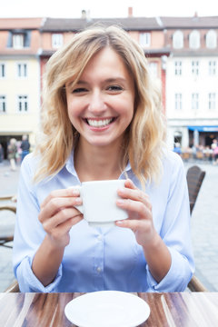 Frau mit blonden Locken macht eine Kaffeepause