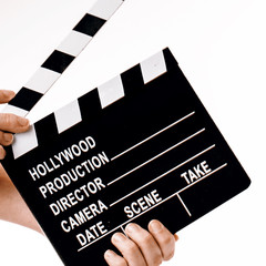 Movie flapper in woman´s hands on white background
