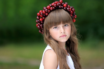 Naklejka premium portrait of little girl with a wreath of cherry