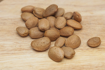 Obraz premium Some almonds in wooden background