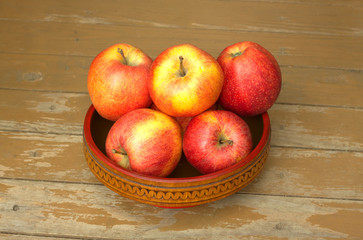 Ripe red and yellow apples in wooden bowl closeup
