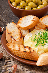Baked Camembert cheese with thyme and toast rubbed with garlic