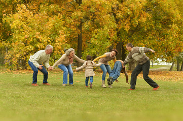 family relaxing in autumn forest