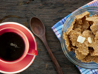 Breakfast cereal with a black coffee on a wooden board