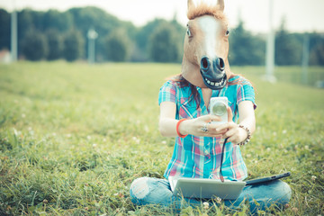 horse mask unreal hipster woman using technology - Powered by Adobe