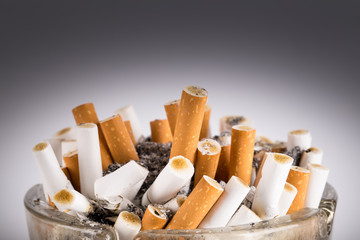 A dirty ashtray with cigarette ash and butts