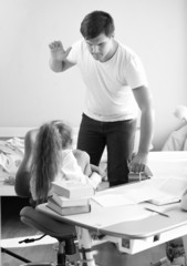 Monochrome shot of angry father hitting intimidated daughter