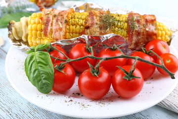 Grilled bacon wrapped corn on table, close-up