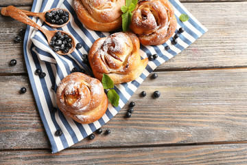 Tasty buns with berries on table close-up