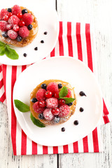 Sweet cakes with berries on table close-up