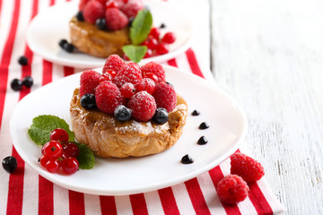 Sweet cakes with berries on table close-up