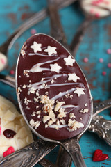 Spoons with tasty chocolate for party on old blue wooden table