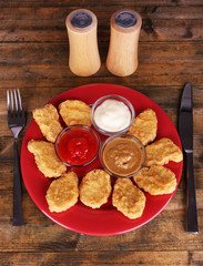 Chicken nuggets with sauces on table close-up