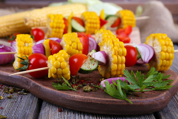 Sliced vegetables on picks on board on table close-up