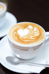 Cups of coffee with cute drawing in cafe