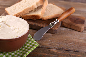 Fresh homemade butter in bowl and sliced bread,