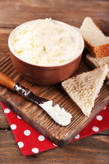 Fresh homemade butter in bowl and sliced bread,