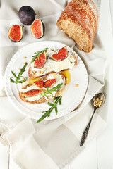 Tasty sandwiches with sweet figs and cottage cheese on plate