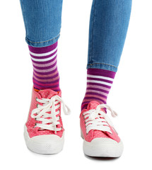 Female legs in colorful socks and sneakers isolated on white