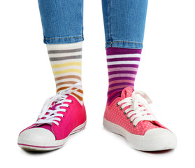 Female legs in colorful socks and sneakers isolated on white