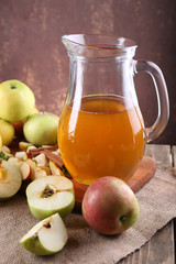 still life with apple cider and fresh apples on wooden table