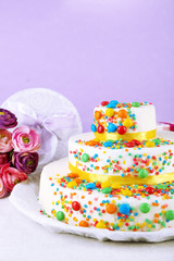 Beautiful tasty birthday cake and gifts on color background