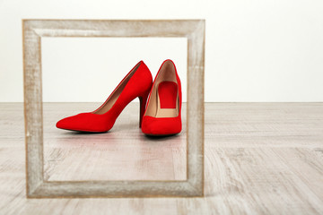 Red women shoes with frame on floor
