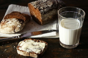 Sliced rye bread, glass of fresh milk and knife