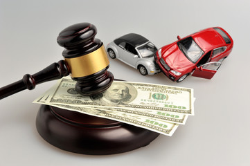 Hammer of judge with money and toy cars on gray
