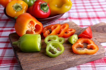 Pepper on plate and on cutting board on fabric background