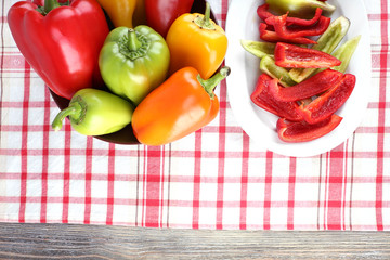 Pepper on oval and round plate on fabric background