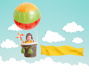 cheerful kid on hot air balloon with banner in the sky