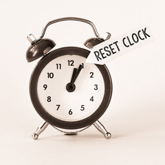 Alarm clock on white background with text reset clock