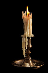 Burning Candle In Old Silver Candlestick Isolated on a Black