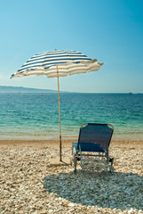 Sunbeds with umbrellas on a beautiful beach with clear water