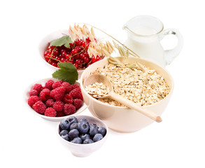 Bowls of oat flakes cereal and various berries