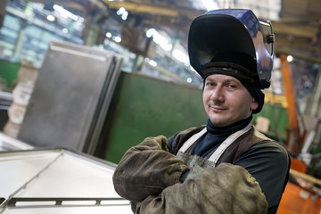 Caucasian welder worker at factory workshop background