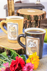 Cups of tea with flowers on wooden table