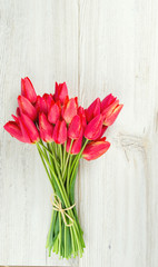 bunch of red tulips on wooden surface