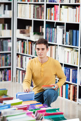 Young man choosing books in a bookstore.