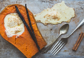 Backed pumpkin half with a scoop of vanilla ice-cream, vanilla s